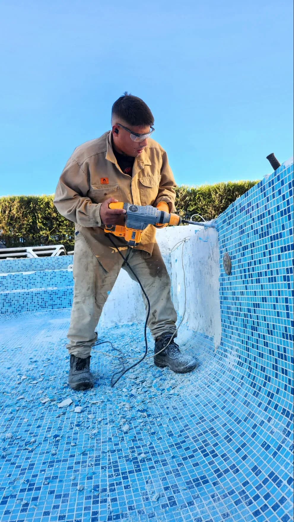 Operario de Obra Azul reparando una pileta